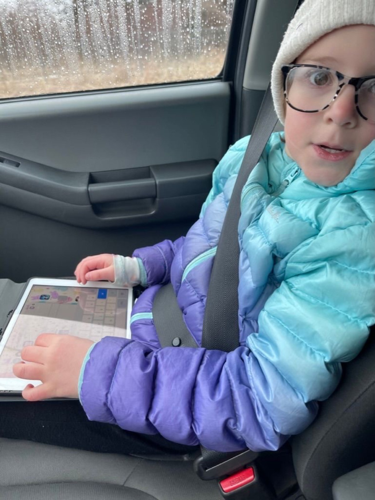 On the way tot school. It isn’t pictured, but she loves to play Mad Libs - and that is the usual car ride activity.
